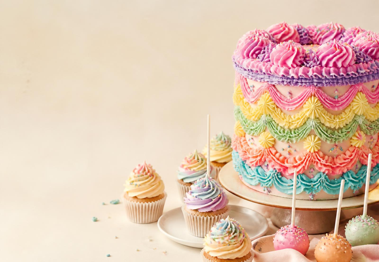 Colourful buttercream celebration cake with cupcakes and cake pops